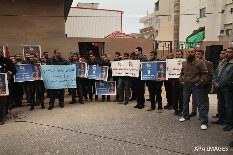 Palestinian journalists hold placards during a protest demanding release of their colleague Alaa al-Titi in Israeli jails, in Gaza city on February 15, 2015. Photo by Ashraf Amra