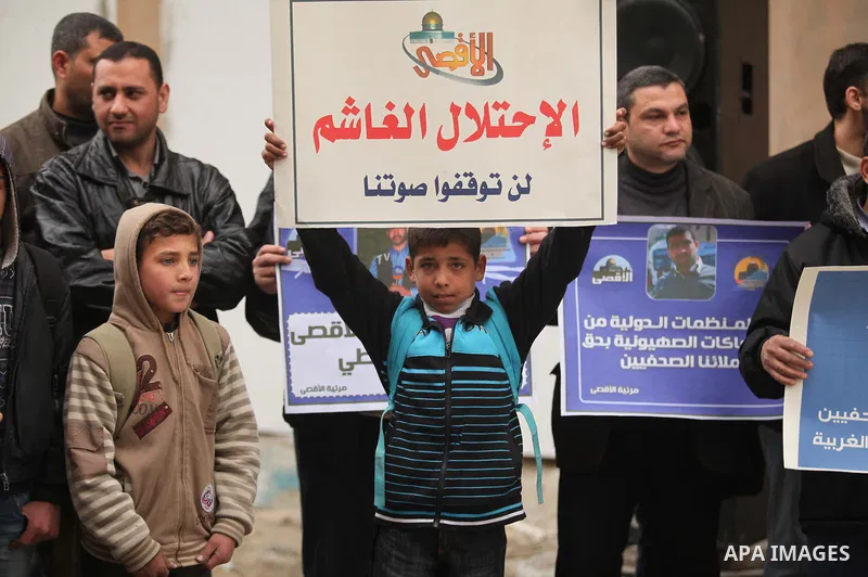 Palestinian journalists hold placards during a protest demanding release of their colleague Alaa al-Titi in Israeli jails, in Gaza city on February 15, 2015. Photo by Ashraf Amra