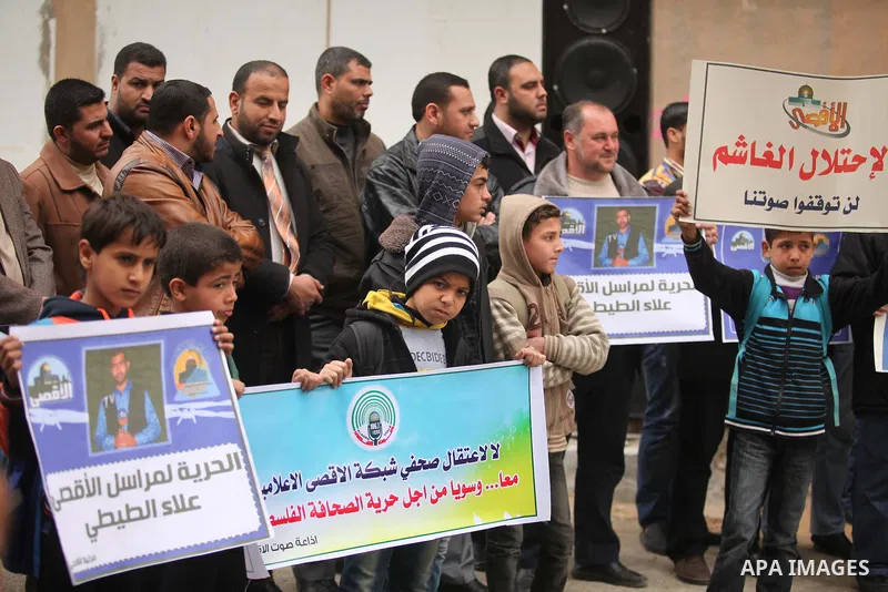 Palestinian journalists hold placards during a protest demanding release of their colleague Alaa al-Titi in Israeli jails, in Gaza city on February 15, 2015. Photo by Ashraf Amra