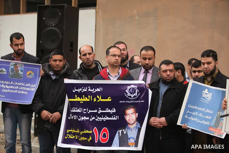 Palestinian journalists hold placards during a protest demanding release of their colleague Alaa al-Titi in Israeli jails, in Gaza city on February 15, 2015. Photo by Ashraf Amra