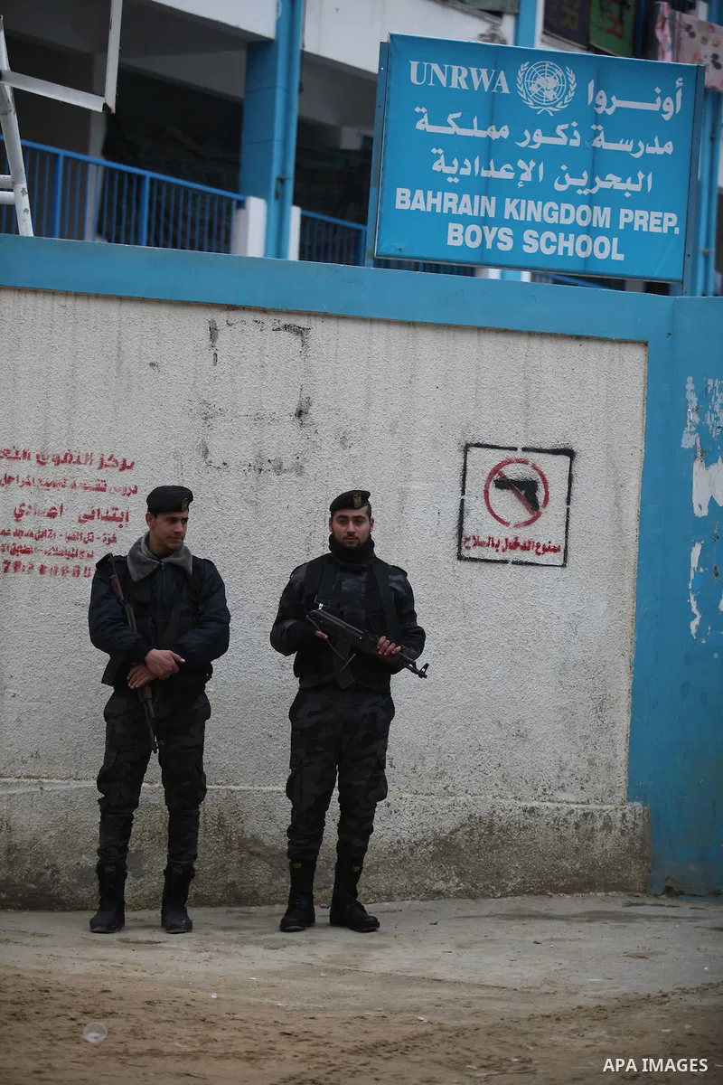 Palestinian policemen stand guard during a visiting of the Quartet Representative to the Middle East and former British Prime Minister, Tony Blair, for a UN-run school sheltering Palestinians, whose houses were destroyed...