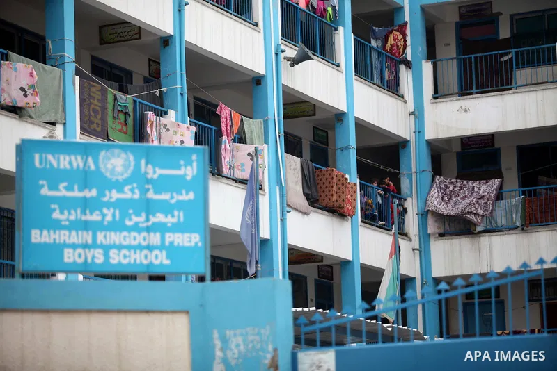 Palestinians stand outside classrooms at a United Nations (UN) run school sheltering Palestinians, whose houses were destroyed in the 50- day-war Israeli last summer, during a visiting of the Quartet Representative to th...