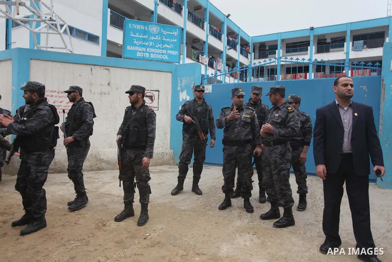 Palestinian policemen stand guard during a visiting of the Quartet Representative to the Middle East and former British Prime Minister, Tony Blair, for a UN-run school sheltering Palestinians, whose houses were destroyed...