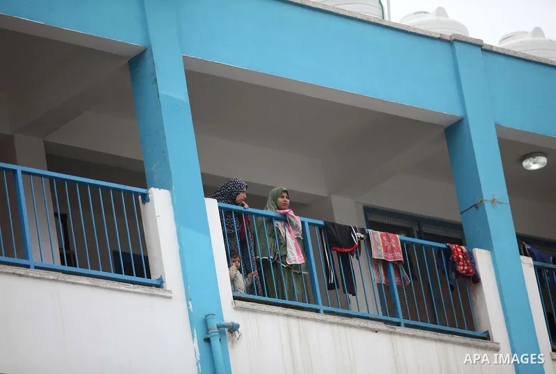 Palestinians stand outside classrooms at a United Nations (UN) run school sheltering Palestinians, whose houses were destroyed in the 50- day-war Israeli last summer, during a visiting of the Quartet Representative to th...