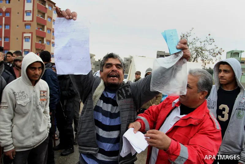 A Palestinian man showing his documents reacts as he takes part with others in a protest calling for reconstruction of their houses that witnesses said were destroyed by Israeli shelling during a 50-day war last summer,...