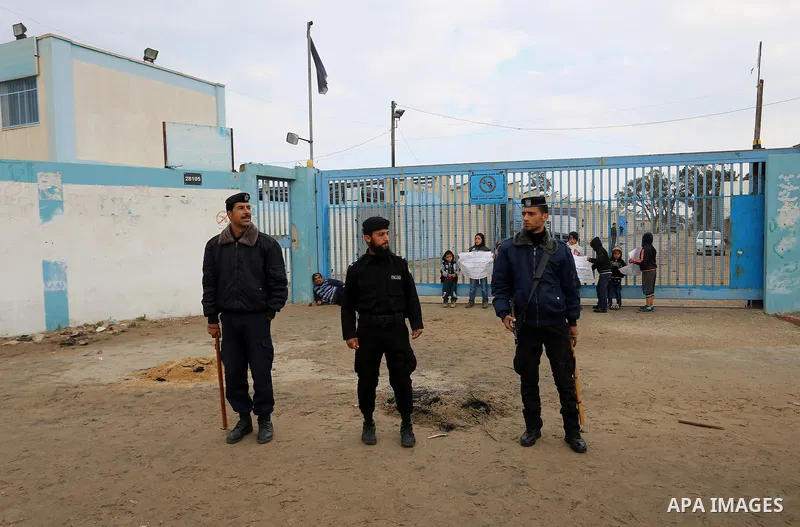 Palestinian policemen loyal to Hamas stand guard near burning tyres during a protest by Palestinians calling for reconstruction of their houses that witnesses said were destroyed by Israeli shelling during a 50-day war l...