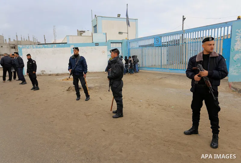 Palestinian policemen loyal to Hamas stand guard near burning tyres during a protest by Palestinians calling for reconstruction of their houses that witnesses said were destroyed by Israeli shelling during a 50-day war l...