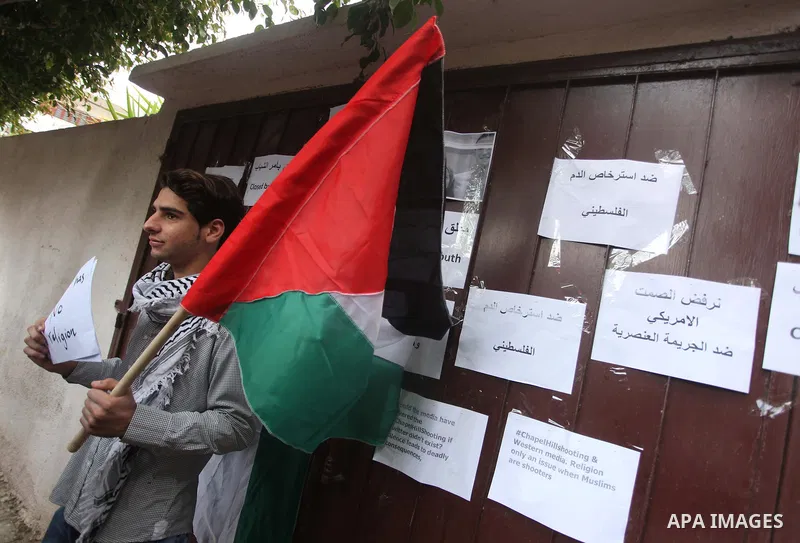 Palestinian youths take part during a protest against the murders of three Muslim students in Carolina, outside the Keir American foundation in Gaza city on February 16, 2015. Craig Stephen Hicks, 46, has been charged wi...