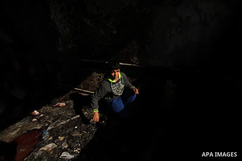 A Palestinian boy looks on as he inspects a burnt classroom at a UN-run school sheltering Palestinians, whose houses were destroyed by what witnesses said was Israeli shelling during a 50-day war last summer, in Biet Han...