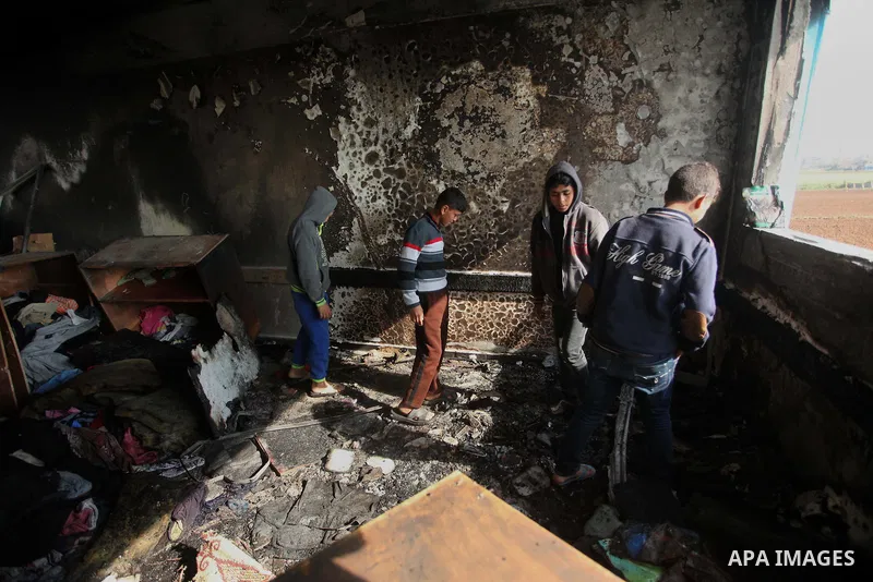 Palestinian men inspect a burnt classroom at a UN-run school sheltering Palestinians, whose houses were destroyed by what witnesses said was Israeli shelling during a 50-day war last summer, in Biet Hanoun in the norther...