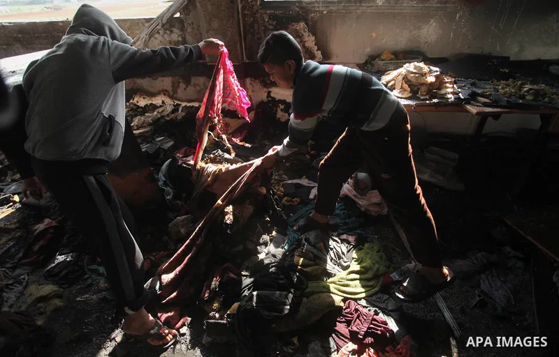 Palestinian men inspect a burnt classroom at a UN-run school sheltering Palestinians, whose houses were destroyed by what witnesses said was Israeli shelling during a 50-day war last summer, in Biet Hanoun in the norther...
