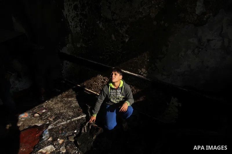 A Palestinian boy looks on as he inspects a burnt classroom at a UN-run school sheltering Palestinians, whose houses were destroyed by what witnesses said was Israeli shelling during a 50-day war last summer, in Biet Han...