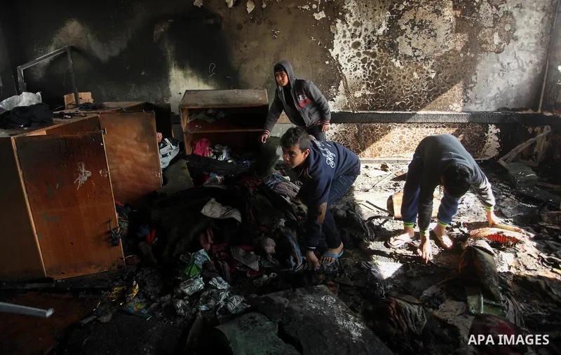 Palestinian men inspect a burnt classroom at a UN-run school sheltering Palestinians, whose houses were destroyed by what witnesses said was Israeli shelling during a 50-day war last summer, in Biet Hanoun in the norther...