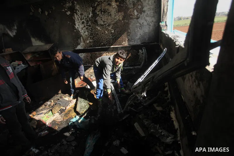 Palestinian men inspect a burnt classroom at a UN-run school sheltering Palestinians, whose houses were destroyed by what witnesses said was Israeli shelling during a 50-day war last summer, in Biet Hanoun in the norther...