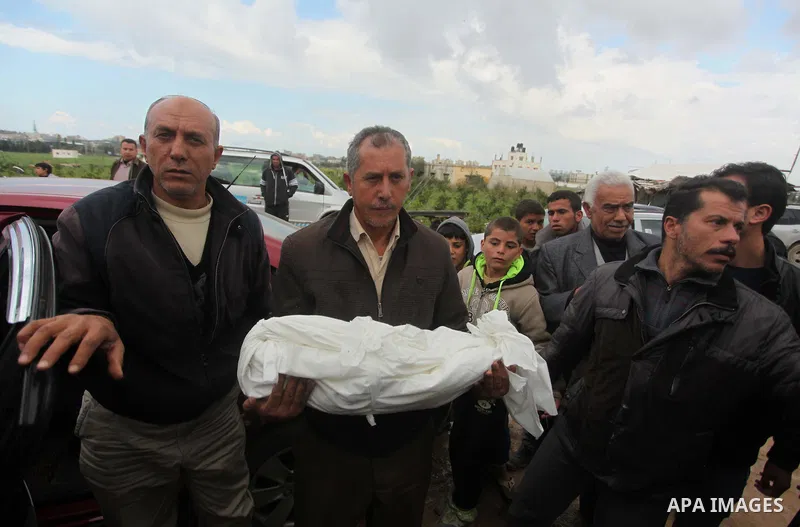 A relative carries the body of Palestinian boy Izz eldeen Al-Kafarana, 9 months old, during his funeral at a UN-run school where he died in Biet Hanoun in the northern Gaza Strip February 17, 2015. Palestinian health off...