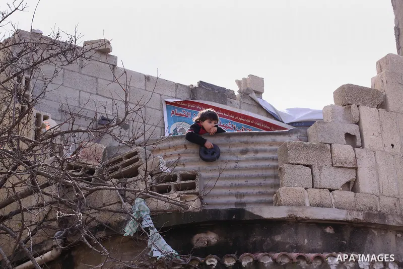 A Palestinian boy stands on his family's house, which was damaged during the recent Israeli war, in Shejaiya neighborhood in Gaza city, February 17, 2015. At least 100,000 Palestinians are still living without adequate s...