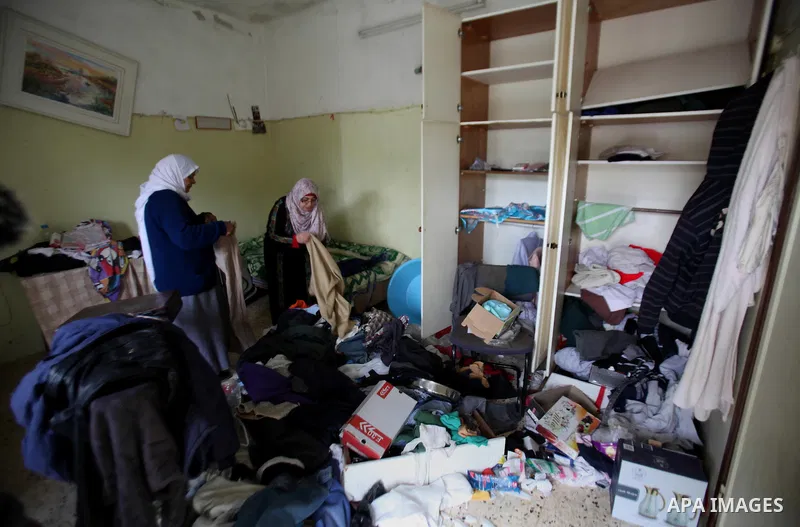 Palestinian women inspect the damages at their house after an Israeli military operation, in the West Bank village of Yatma south of Nablus Feb. 18, 2015. Israeli troops stormed three Palestinian villages in Nablus distr...