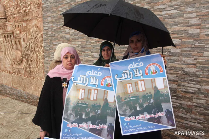 Palestinian employees of former Palestinian government take part a protest demanding their salaries to be paid, in front of the Legislative Council in Gaza city on February 18, 2015. Some 40,000 civil servants employed b...
