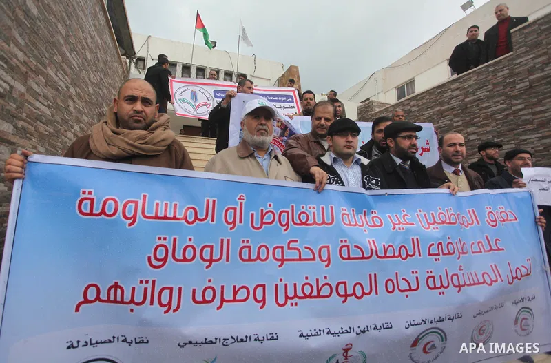 Palestinian employees of former Palestinian government take part a protest demanding their salaries to be paid, in front of the Legislative Council in Gaza city on February 18, 2015. Some 40,000 civil servants employed b...