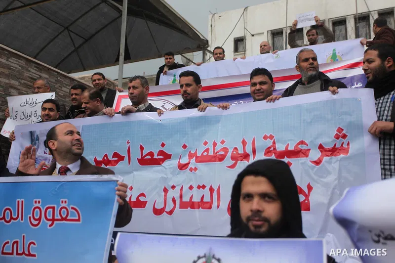 Palestinian employees of former Palestinian government take part a protest demanding their salaries to be paid, in front of the Legislative Council in Gaza city on February 18, 2015. Some 40,000 civil servants employed b...