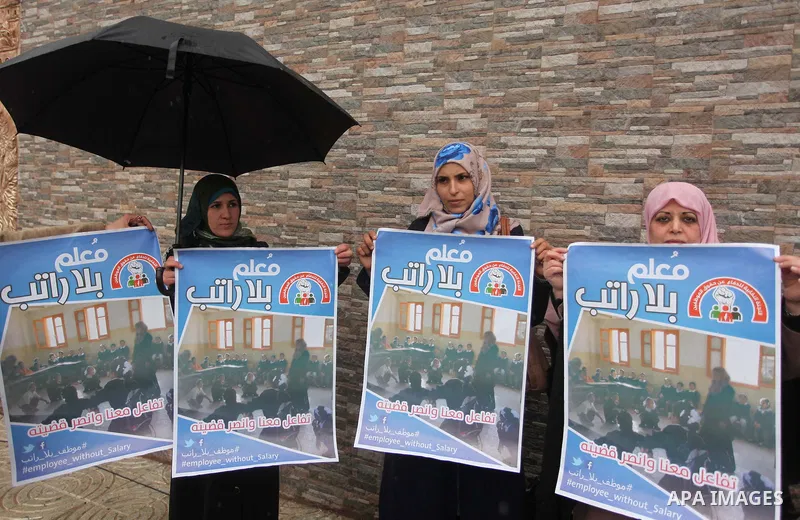 Palestinian employees of former Palestinian government take part a protest demanding their salaries to be paid, in front of the Legislative Council in Gaza city on February 18, 2015. Some 40,000 civil servants employed b...