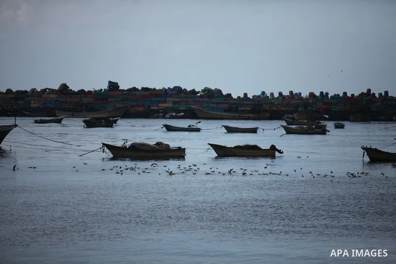 Palestinian fishermen ride their boat during a rainy day at the seaport near the coast of Gaza city, February 18, 2015. Photo by Ashraf Amra