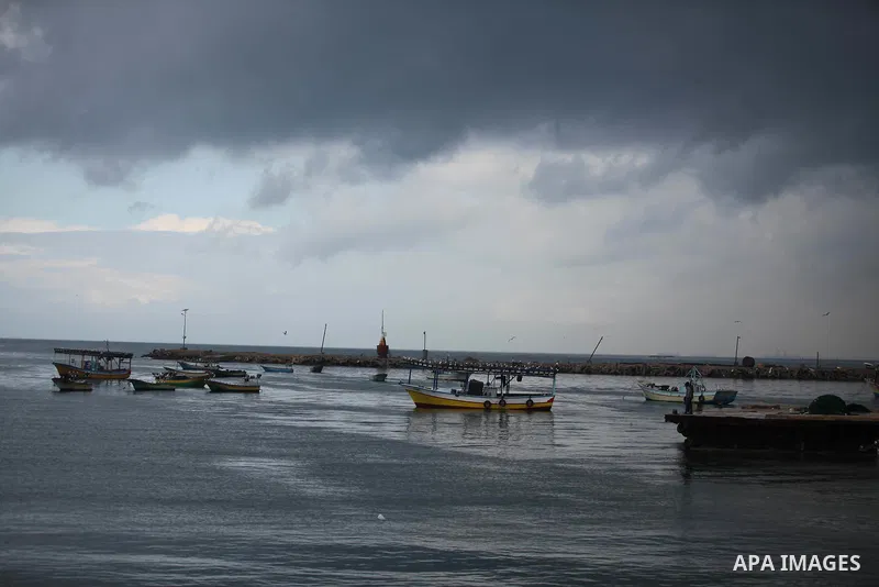 Palestinian fishermen ride their boat during a rainy day at the seaport near the coast of Gaza city, February 18, 2015. Photo by Ashraf Amra