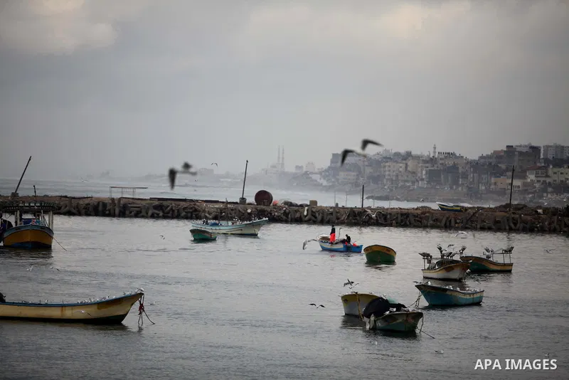 Palestinian fishermen ride their boat during a rainy day at the seaport near the coast of Gaza city, February 18, 2015. Photo by Ashraf Amra