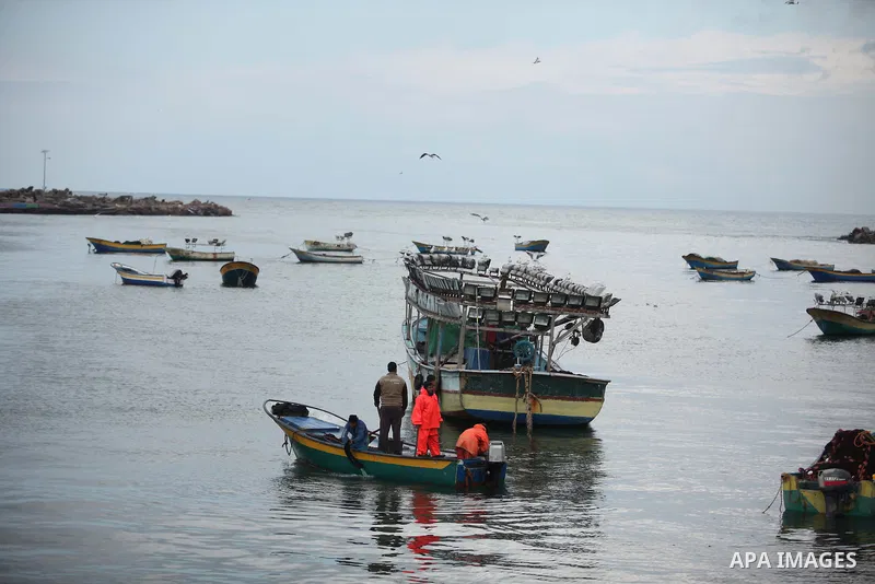 Palestinian fishermen ride their boat during a rainy day at the seaport near the coast of Gaza city, February 18, 2015. Photo by Ashraf Amra