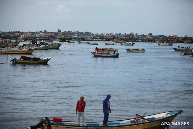 Palestinian fishermen ride their boat during a rainy day at the seaport near the coast of Gaza city, February 18, 2015. Photo by Ashraf Amra