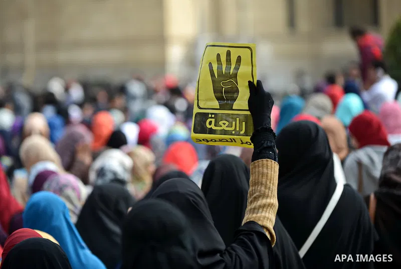 An Egyptian student who support ousted President Mohamed Morsi and the Muslim Brotherhood, holds Rabaa sign during protest against the military rule, in Cairo University on February 18, 2015. Due to the escalation of stu...