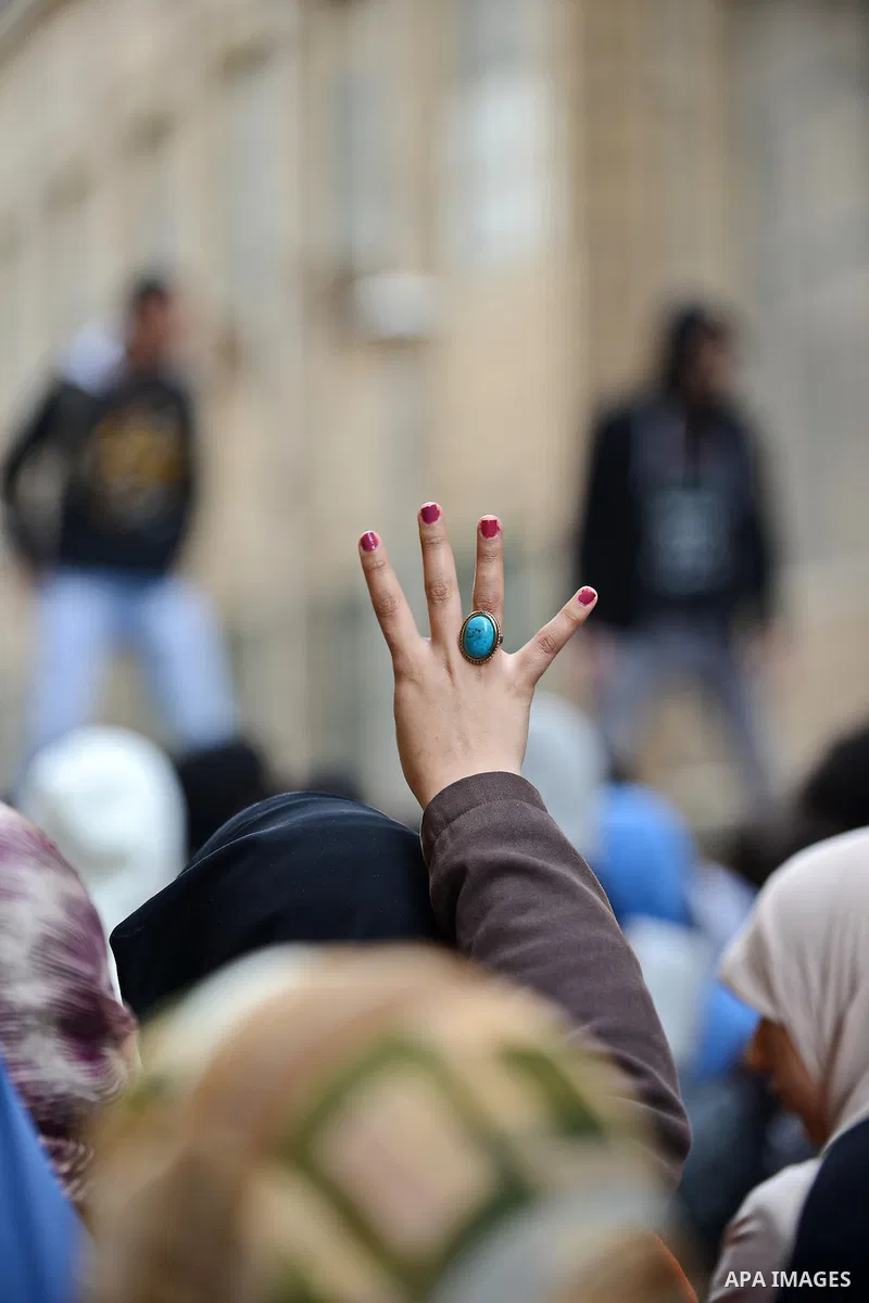 An Egyptian student who support ousted President Mohamed Morsi and the Muslim Brotherhood, flashes Rabaa sign during protest against the military rule, in Cairo University on February 18, 2015. Due to the escalation of s...