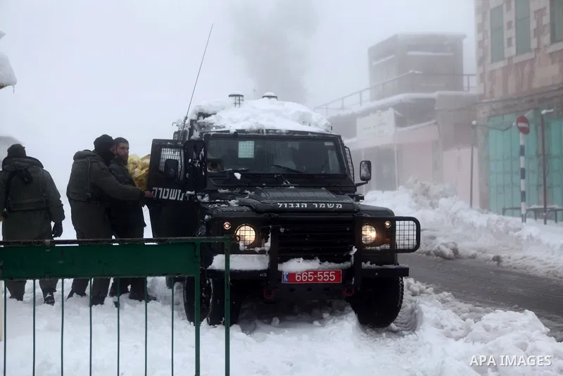 Israeli soldiers stand guard outside Ibrahimi Mosque as snow falls in the West Bank city of Hebron February 20, 2015. A heavy winter storm hit parts of the Middle East on Friday, shutting down roads leading in and out of...