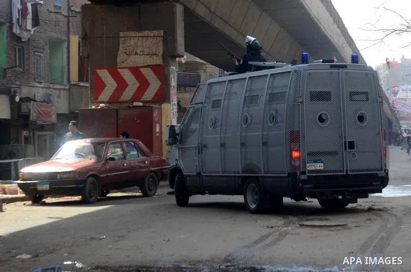 Egyptian riot policemen stand guard during clashes with supporters of Muslim Brotherhood and ousted Islamist President Mohamed Morsi in Talbiya district, near Cairo on February 20, 2015. Photo by Amr Sayed