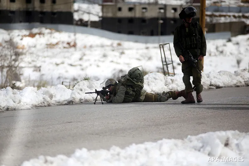 Israeli security forces stand guard during clashes with Palestinian youths from the Jalazoun refugee camp (unseen), on the road at the entrance of the Jewish West Bank settlement Beit El, north of Ramallah, following a p...
