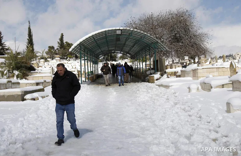 Palestinians walk in a snow-covered cemetery following Friday prayers in the al-Aqsa mosque compound in Jerusalem's old city on February 20, 2015. A heavy winter storm hit parts of the Middle East on Friday, shutting dow...