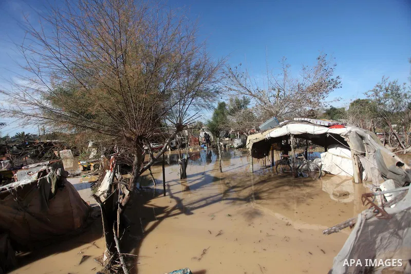 A Palestinian man salvages his belongings from his dwelling after it was flooded by rain water in the village of Al-Moghraga near central Gaza Strip February 22, 2015. Palestinian authorities said the Israeli army opened...
