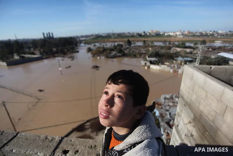 Palestinians evacuate their dwelling in the village of Al-Moghraga after it was flooded by rain water, near central Gaza Strip February 22, 2015. Palestinian authorities said the Israeli army opened the floodgates of a c...