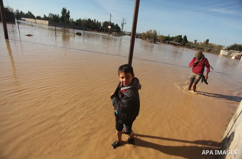 Palestinians evacuate their dwelling in the village of Al-Moghraga after it was flooded by rain water, near central Gaza Strip February 22, 2015. Palestinian authorities said the Israeli army opened the floodgates of a c...