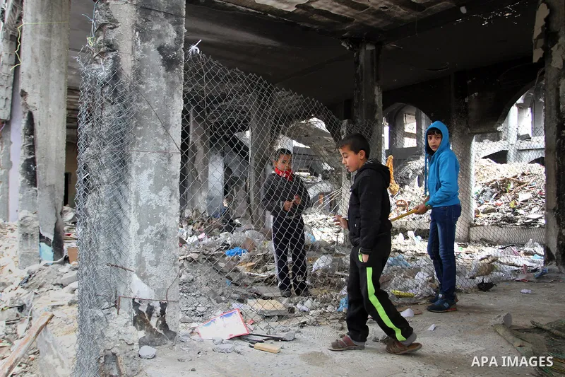 Palestinian children walk on the rubbles of their family's house, which was destoryed during the recent Israeli war, in Rafah in the southern Gaza strip, February 22, 2015. At least 100,000 Palestinians are still living...
