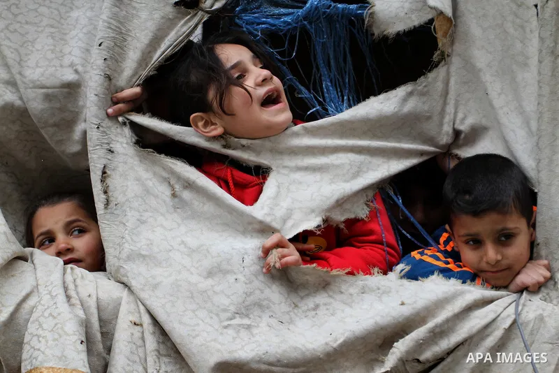 Palestinian children play on the remains of destroyed houses, which were damaged during the recent Israeli war, in Rafah in the southern Gaza strip, February 22, 2015. At least 100,000 Palestinians are still living witho...