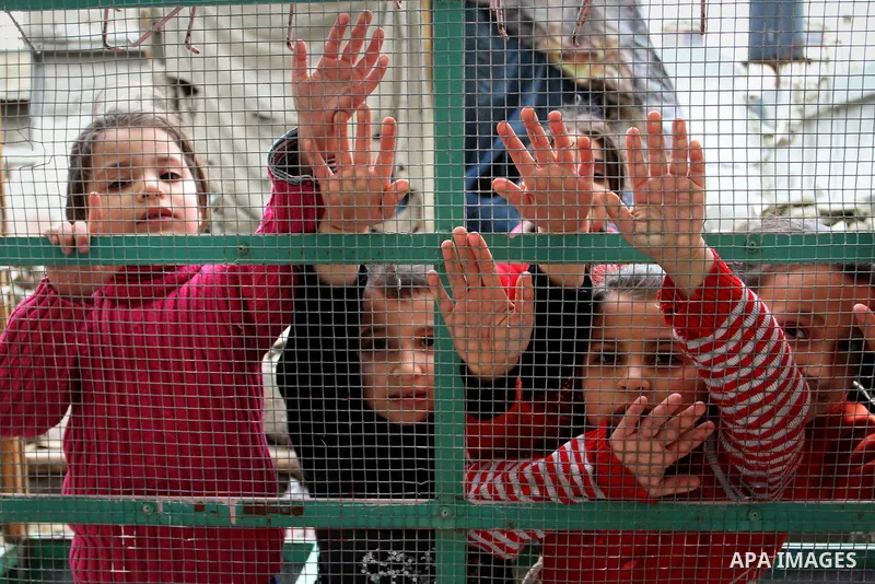Palestinian children play on the remains of destroyed houses, which were damaged during the recent Israeli war, in Rafah in the southern Gaza strip, February 22, 2015. At least 100,000 Palestinians are still living witho...