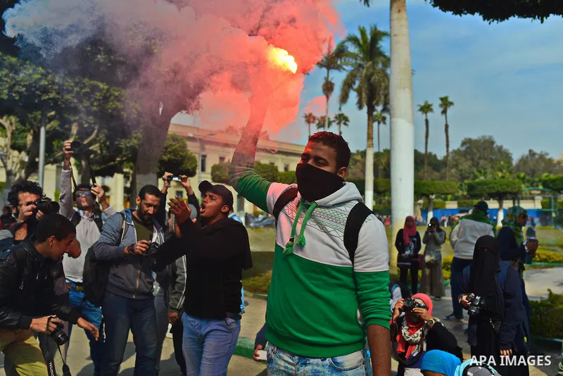 An Egyptian student who support ousted President Mohamed Morsi and the Muslim Brotherhood lights up flares as others protest against the military rule, in Cairo University on February 22, 2015. Due to the escalation of s...