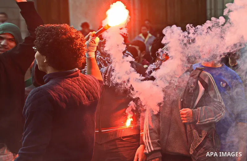 An Egyptian student who support ousted President Mohamed Morsi and the Muslim Brotherhood lights up flares as others protest against the military rule, in Cairo University on February 22, 2015. Due to the escalation of s...