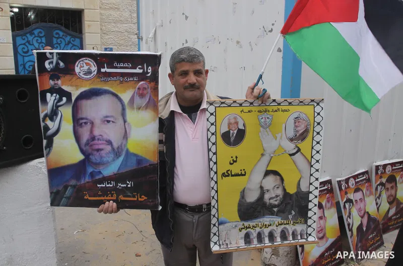 Palestinians hold placards during a protest calling for the release of Palestinian prisoners from Israeli jails, in front of the United Nations Development Programme office (UNDP) in Gaza City, on February 24, 2015. Phot...