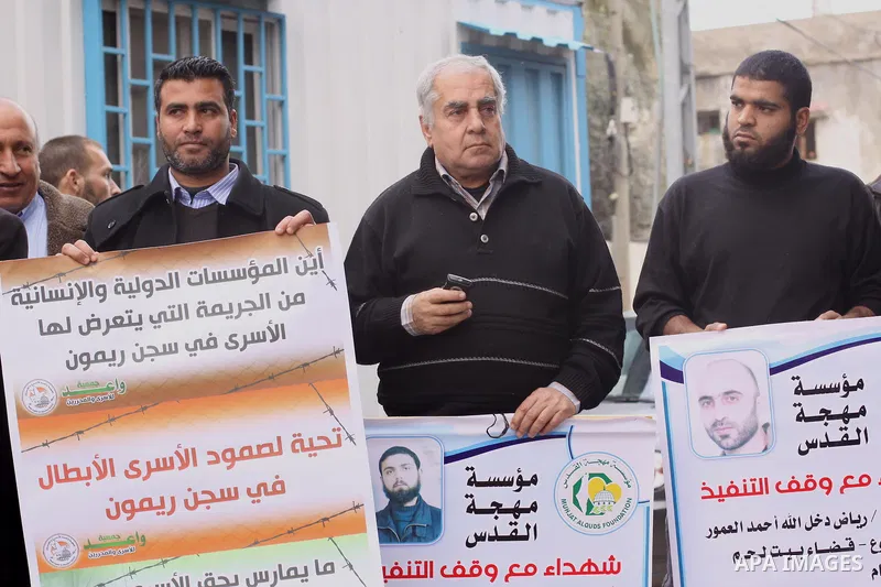 Palestinians hold placards during a protest calling for the release of Palestinian prisoners from Israeli jails, in front of the United Nations Development Programme office (UNDP) in Gaza City, on February 24, 2015. Phot...
