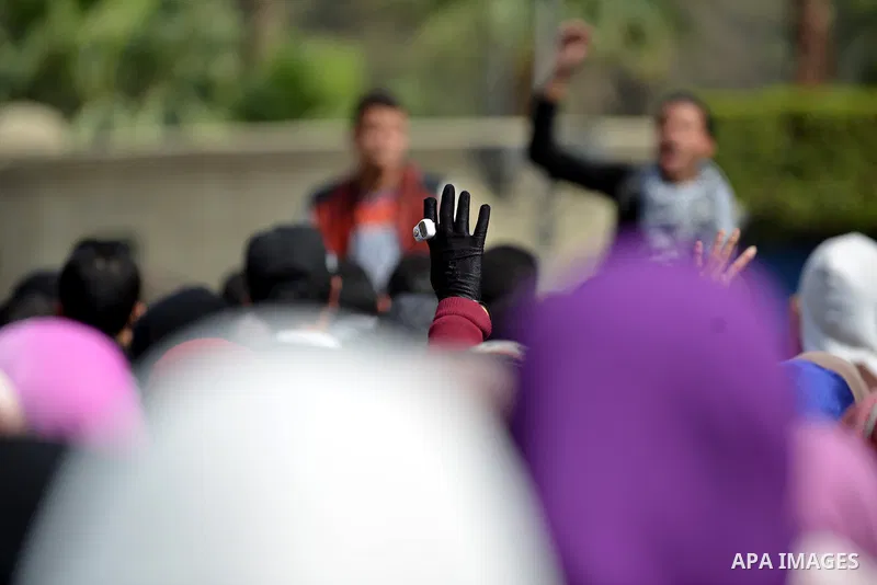 An Egyptian student who support ousted President Mohamed Morsi and the Muslim Brotherhood, flashes Rabaa sign during protest against the military rule, in Cairo University on February 24, 2015. Due to the escalation of s...