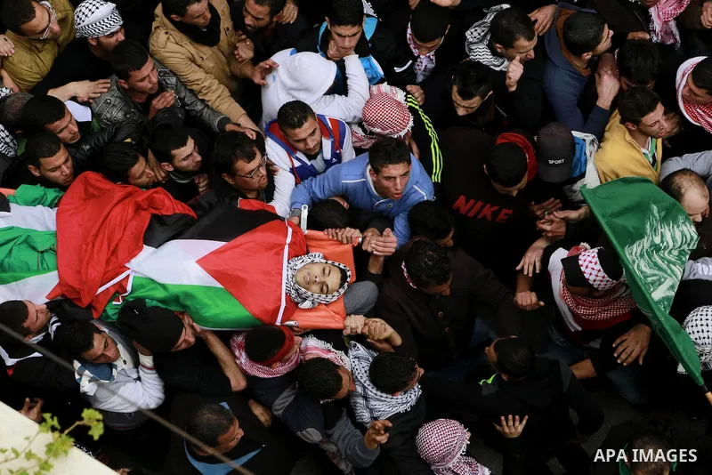 Palestinian mourners carry the body of 19-year old Palestinian Jihad al-Jaafari, who was shot dead on the roof of his house after Israeli soldiers entered the Dheishe refugee camp, near the West Bank city of Bethlehem be...