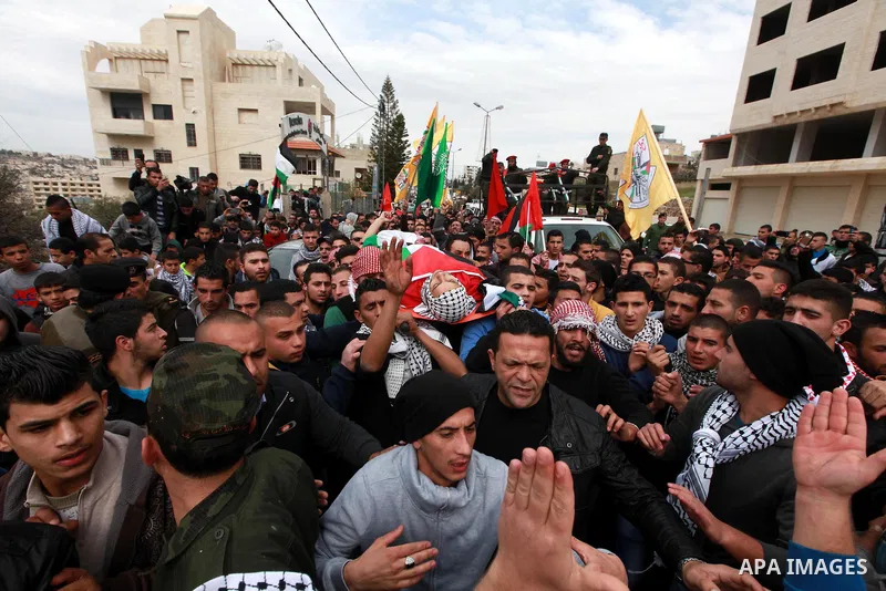 Palestinian mourners carry the body of 19-year old Palestinian Jihad al-Jaafari, who was shot dead on the roof of his house after Israeli soldiers entered the Dheishe refugee camp, near the West Bank city of Bethlehem be...