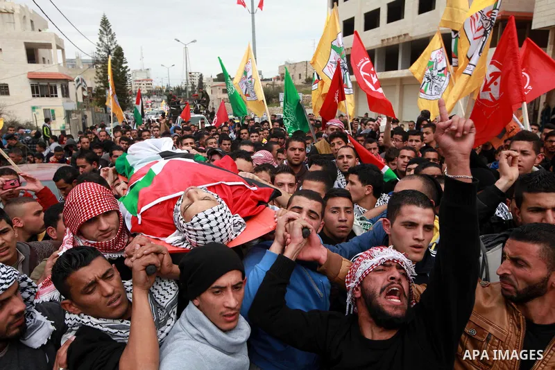 Palestinian mourners carry the body of 19-year old Palestinian Jihad al-Jaafari, who was shot dead on the roof of his house after Israeli soldiers entered the Dheishe refugee camp, near the West Bank city of Bethlehem be...